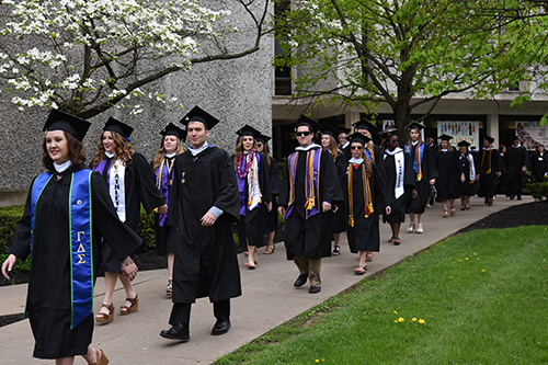 Graduates begin their trip to the center of campus. 
